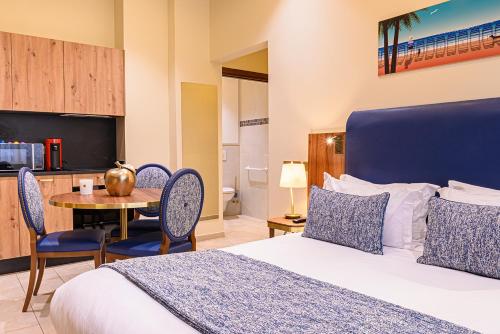 a bedroom with a bed and a table with chairs at Résidence Aston la Scala in Nice