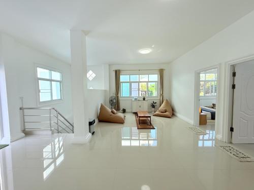 a living room with white walls and a staircase at Coastal Nomad Ocean View Stay - 1 or 2 Rooms in Ban Pak Khlong Phe