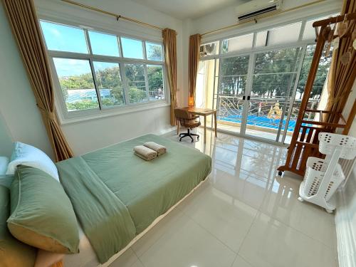 a bedroom with a bed with two towels on it at Coastal Nomad Ocean View Stay - 1 or 2 Rooms in Ban Pak Khlong Phe