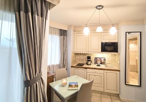 a kitchen with a table and a dining room at Reflets du Lac Annecy, Baie des Voiles - Vue Lac - Terrasse - Plage & Parking Privés in Duingt