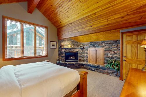 a bedroom with a bed and a fireplace at Coyote Creek Chalet in Big White
