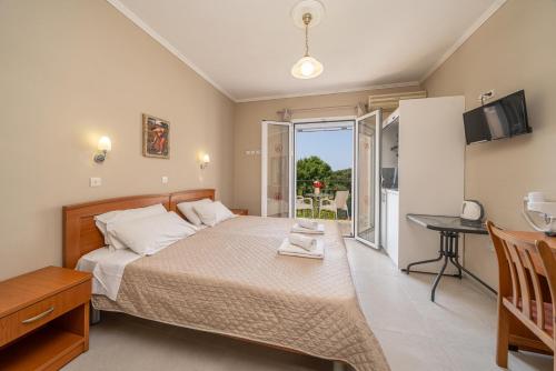 a bedroom with a bed and a table and a balcony at Dionysios Studios in Skala
