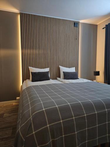 a bedroom with a large bed with a blue blanket at Leilighet Vingnes in Lillehammer