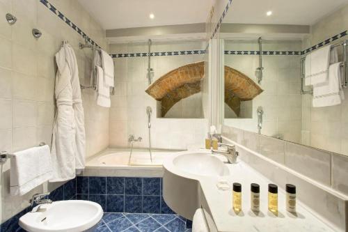 a bathroom with a sink and a tub and a toilet at Grand Hotel Cavour in Florence
