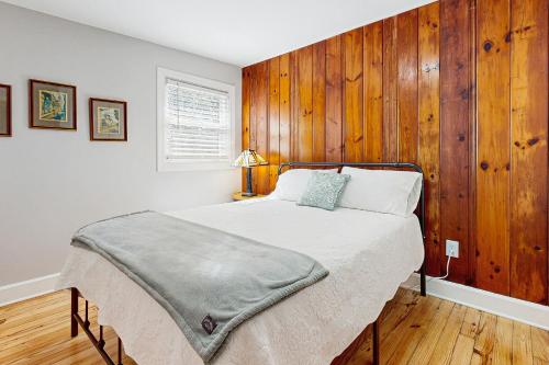 a bedroom with a bed with a wooden wall at Private Patio & Pond: Serene Black Mountain Escape in Black Mountain