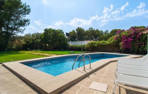 a swimming pool in a yard with a white bench at El Tulipan Blanco in Alcudia