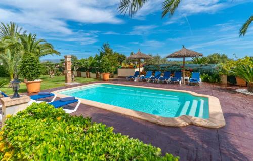 a swimming pool in a yard with chairs and umbrellas at Ca Na Pepa in Muro