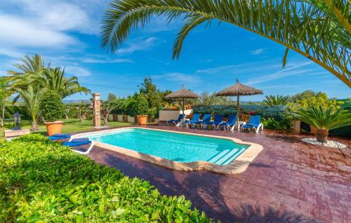 a swimming pool in a yard with chairs and umbrellas at Ca Na Pepa in Muro