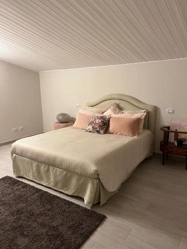 a bedroom with a large bed with pink pillows at A casa di Lena in Genzano di Roma