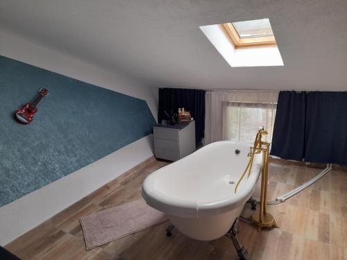 a bathroom with a white tub and a guitar on the wall at Lotru Relax Chalet in Malaia