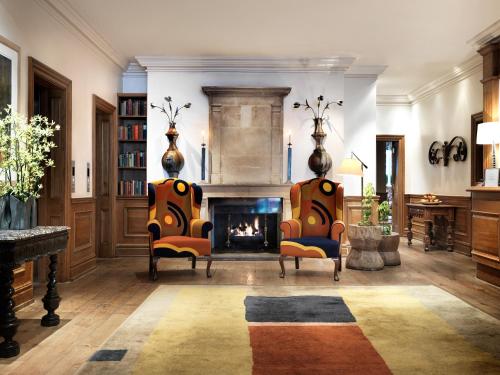 two chairs in a living room with a fireplace at Charlotte Street Hotel, Firmdale Hotels in London