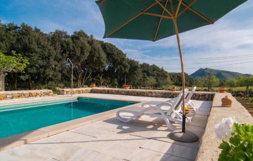 a chair and an umbrella next to a swimming pool at Son Frare in Artá
