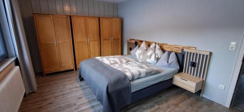 a bedroom with a bed and wooden cabinets at Apartmenthaus Hinterer in Bad Goisern