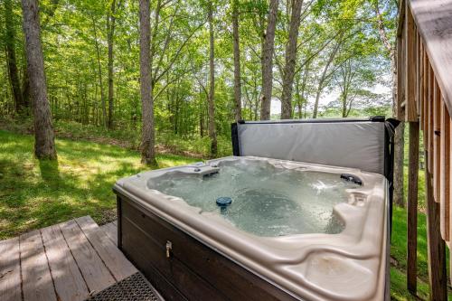a hot tub sitting on a deck in the woods at Meadow Lake View by Railey Vacations in Swanton
