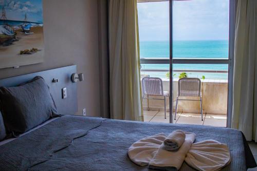 a bedroom with a bed with a view of the ocean at TerrazzoPontaNegraDJ in Natal