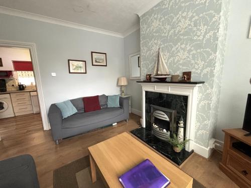 a living room with a couch and a fireplace at Downs Gate Cottage in Eastbourne