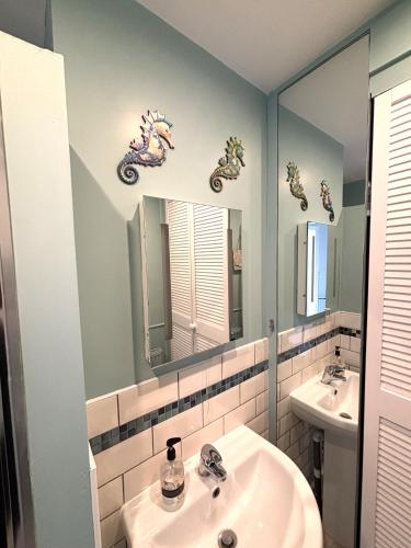 a bathroom with a sink and a mirror at Downs Gate Cottage in Eastbourne