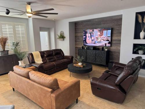 a living room with leather furniture and a flat screen tv at Homes by Abby LLC in Maricopa
