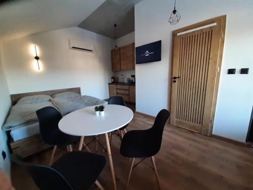 a room with a table and chairs and a bed at Apartament 12 in Zwardoń