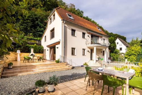 a house with a patio with a table and chairs at Elbvilla Pirna mit Sauna und Kamin mit privatem Zugang zur Elbe in Pirna
