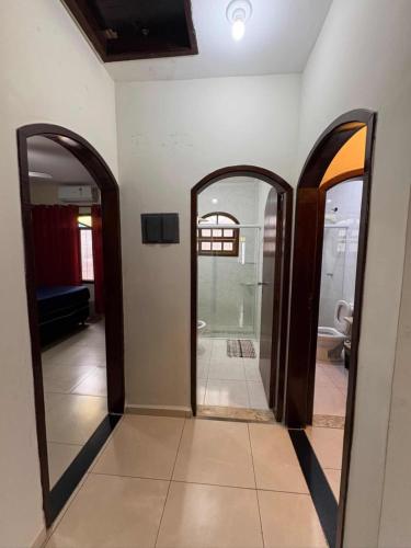 a hallway with two mirrors in a bathroom at Casa com piscina in Bertioga