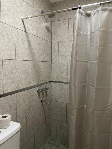 a shower with a shower curtain in a bathroom at Casa de Lore in Necochea