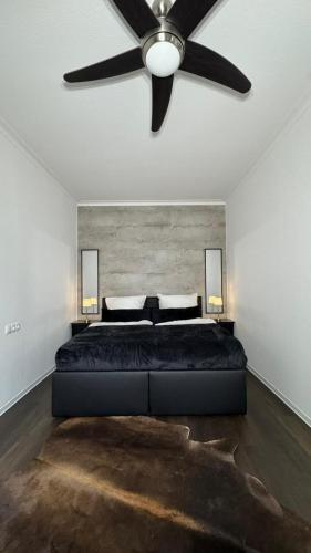 a bedroom with a large bed with a ceiling fan at Paulus Living in Halle an der Saale