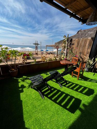 a patio with a bench and a view of the beach at Che Zipolite Hostel & Beach Club in Zipolite