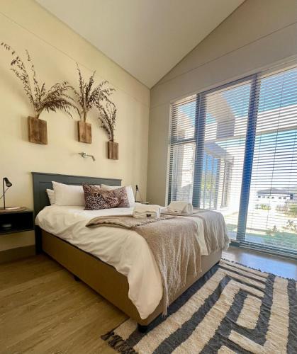 a bedroom with a bed and a large window at House Vos in Hermanus