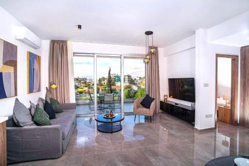 a living room with a couch and a tv at Celeste Suites in Limassol