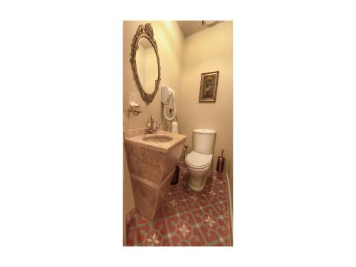 a bathroom with a sink and a toilet and a mirror at Hotel Troya Balat in Istanbul