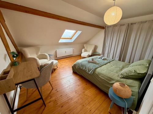 a bedroom with a bed and a desk and a window at Sweet Harmonie in Grand-Fort-Philippe