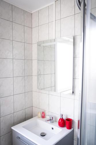 a white bathroom with a sink and a mirror at Sweet Harmonie in Grand-Fort-Philippe