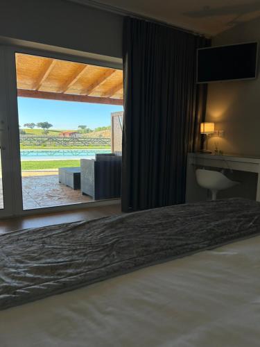a bedroom with a bed and a window with a view at Herdade do Serra in Ervidel