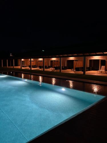 a swimming pool lit up at night at Herdade do Serra in Ervidel