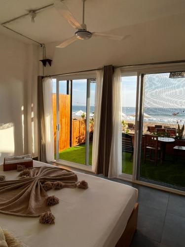 a bedroom with a bed and a view of the ocean at Che Zipolite Hostel & Beach Club in Zipolite