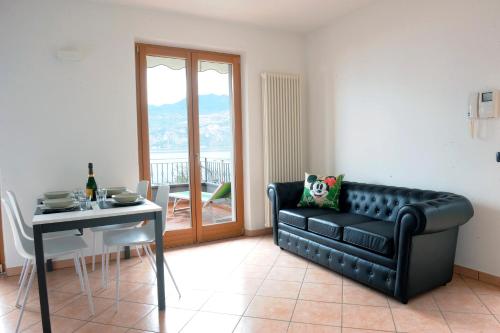 a living room with a black leather couch and a table at Casa Pagani in Brenzone sul Garda