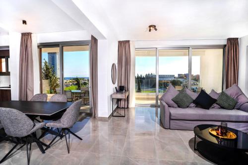 a living room with a couch and a table and chairs at Celeste Suites in Limassol