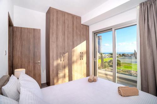 a bedroom with a bed and a large window at Celeste Suites in Limassol