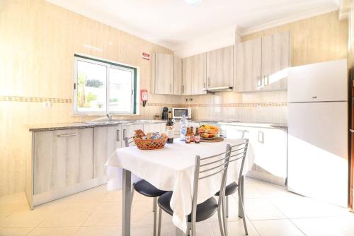 a kitchen with a table with a bowl of fruit on it at Vila Alcantarilha by MTPhomes in Alcantarilha