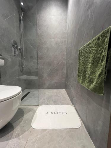a bathroom with a shower with a suite sign on the floor at A Suites in Casablanca