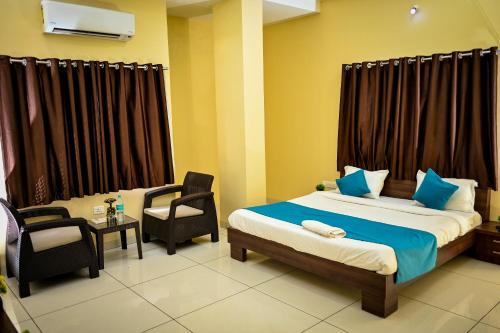 a bedroom with a bed and a desk and a chair at The Shrine Hotel in Godarpura