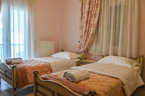 a bedroom with two beds and a window at Soula's Traditional House in Kalabaka