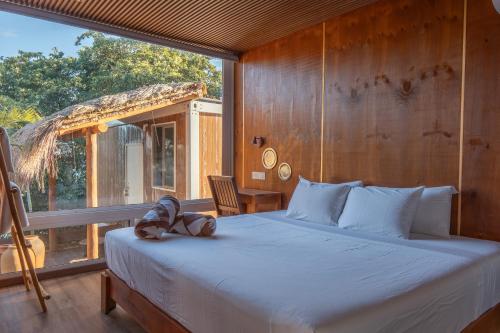 a bedroom with a bed with a teddy bear on it at Tregua Bacalar in Bacalar