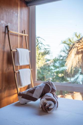 a towel sitting on a bed next to a chair at Tregua Bacalar in Bacalar