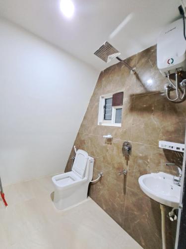 a bathroom with a toilet and a sink at Mung Kham Stays in Jorhat