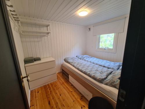a small bedroom with a bed and a window at Nordfjordcabins RED in Utvik