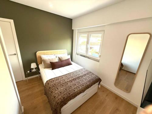 a small bedroom with a bed and a mirror at Estoril by the Sea in Estoril