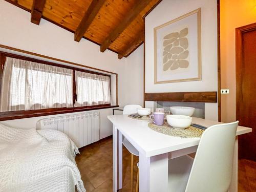 a white dining room with a white table and chairs at La Maison Pilly in Sondalo