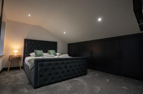 a bedroom with a large bed with a black headboard at Rose House in Boston